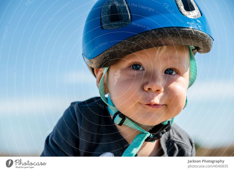 Porträt eines süßen kleinen Jungen mit blauem Fahrradhelm vor blauem Himmel Schutzhelm Menschen Kind Sohn Familie Glück Spaß Kaukasier im Freien Tag Kindheit