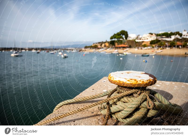 Blick auf die Fischereileine im Hafen von Alvor mit Stadtbild im Hintergrund, Südportugal Küste alvor Algarve Textfreiraum Linie Ribeira de Odiaxere Kai
