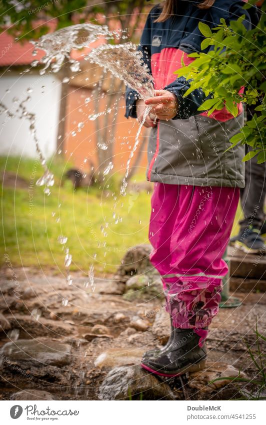 Leichtigkeit | Ein Mädchen spritzt Wasser mit dem Wasserschlauch Kind Farbfoto Kindheit Mensch Außenaufnahme Freude positiv 3-8 Jahre Neugier Tag spass