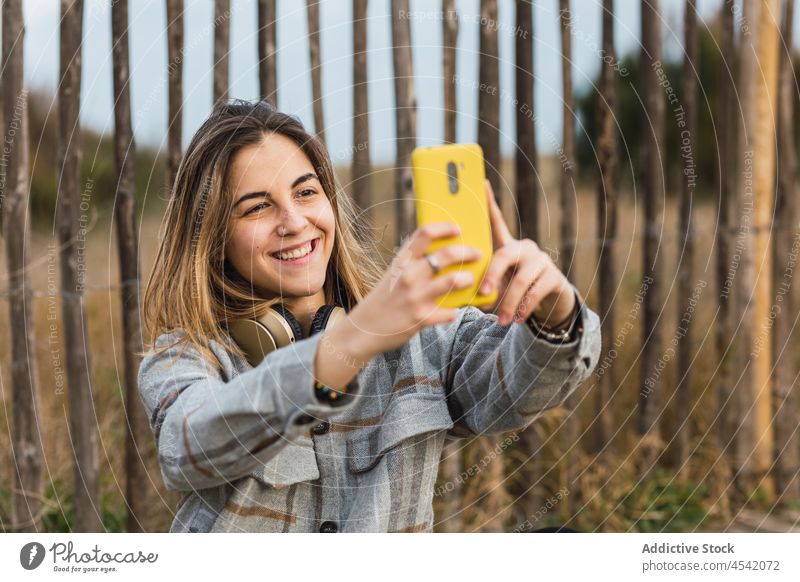 Junge Frau nimmt Selfie auf Smartphone witting auf hölzernen Weg Landschaft Promenade sich[Akk] entspannen Fotografie fotografieren Natur soziale Netzwerke