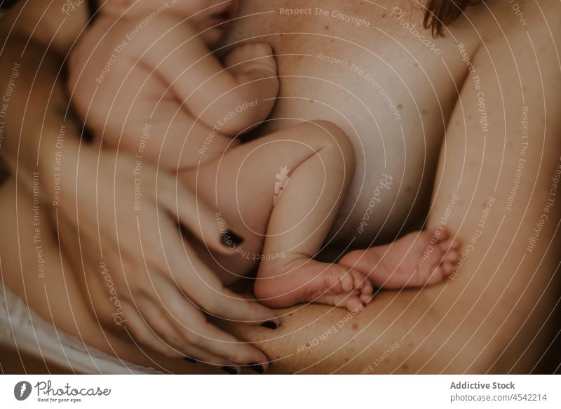Anonyme Mutter, die ihr Baby umarmt, während sie auf einem Stuhl sitzt Frau Umarmen neugeboren stillen Liebe Umarmung nackt Zusammensein Mutterschaft Kindheit