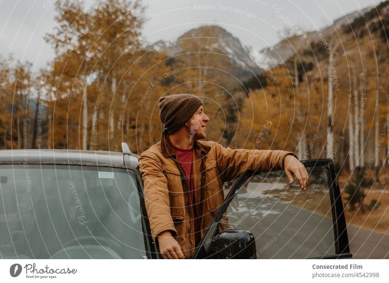 Mann in den Bergen im Herbst lehnt sich aus dem Auto an der Tür Espen Aspen Colorado Herbstlaub fallen Laubwerk reisen Abenteuer Abenteurer Birke gelb