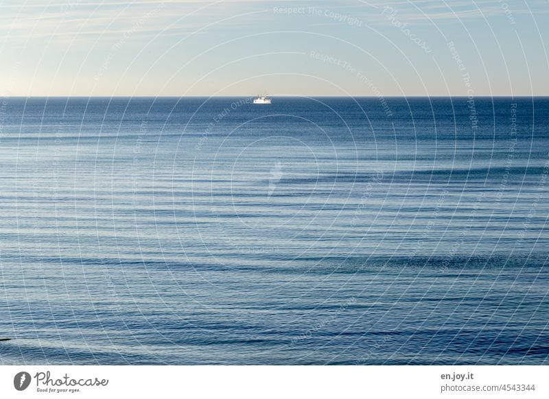 Ahoi - ein kleines weißes Schiff in der Mitte des großen Ozeans ganz hinten am Horizont Meer Wellen Wasser Himmel blau Urlaub Reise See Seereise Schiffsfahrt