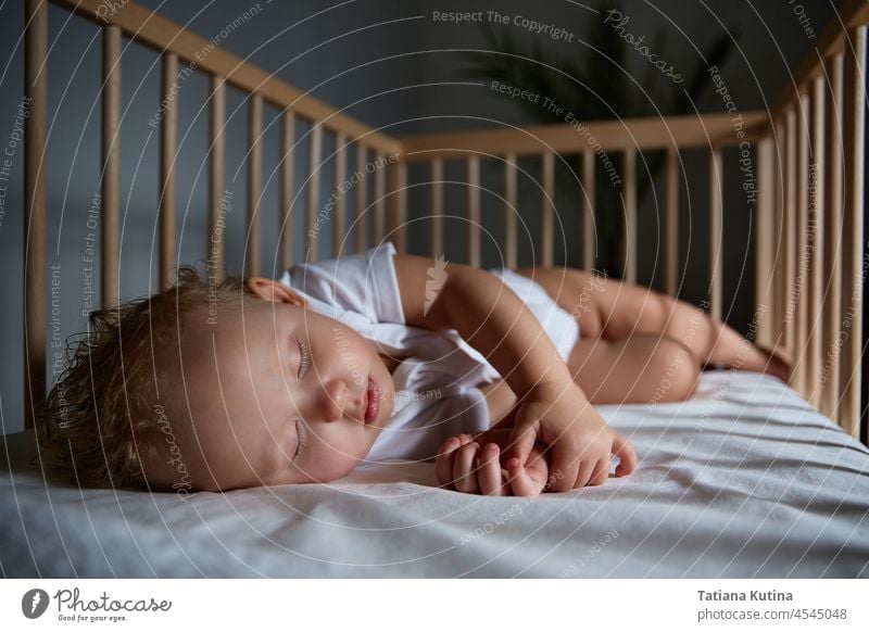 Niedliches Baby schläft nachts in einer Wiege für Babys ohne Baldachin und Stoßdämpfer. Nacht schlafen Säugling Bett Abend Mittagsschlaf Kinderbett Stubenwagen