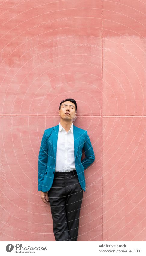 Stilvoller asiatischer Mann im Anzug formal Straße Outfit elegant Wand Unternehmer fettarm respektabel gut gekleidet Augen geschlossen Bekleidung Geschäftsmann