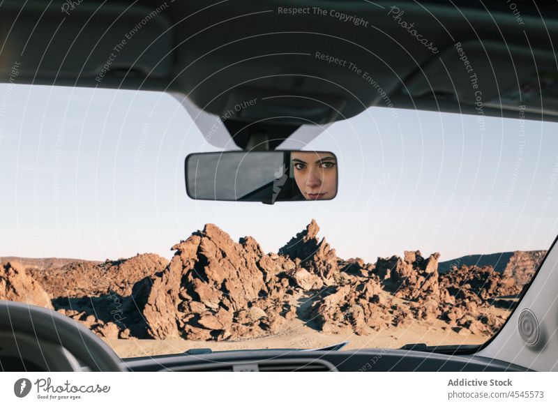 Frau schaut im Auto in der Natur in den Spiegel PKW Automobil Windschutzscheibe felsig Formation Ausflug Abenteuer Autoreise Fahrer Fahrzeug geparkt steinig