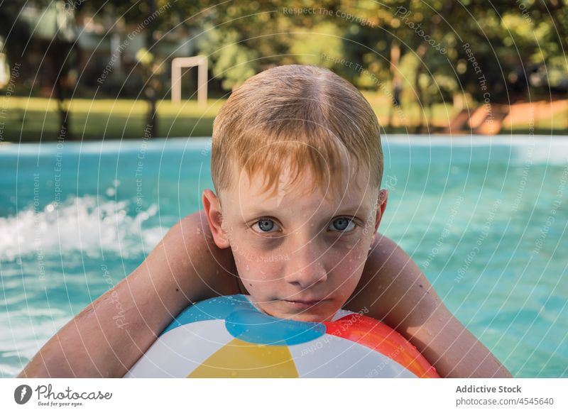 Kind lehnt sich beim Schwimmen im Freibad an einen aufblasbaren Ball schwimmen Pool Urlaub sich[Akk] entspannen Windstille Feiertag Junge Resort ruhen