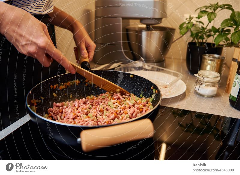 Frau kocht Sauce Bolognese in der Küche Essen zubereiten Pfanne Saucen Ragu Bestandteil vorbereitend Herd Gesundheit Löffel Topf heiß Haus Italienisch Fleisch