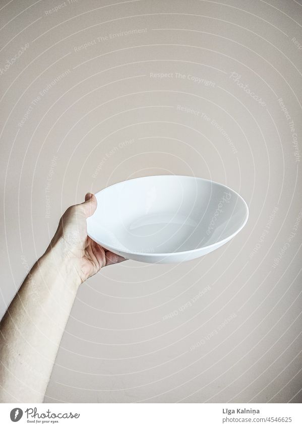 Hand hält einen leeren weißen Teller Tellerrand Foodfotografie Textfreiraum oben Detailaufnahme Lebensmittel Innenaufnahme Beteiligung