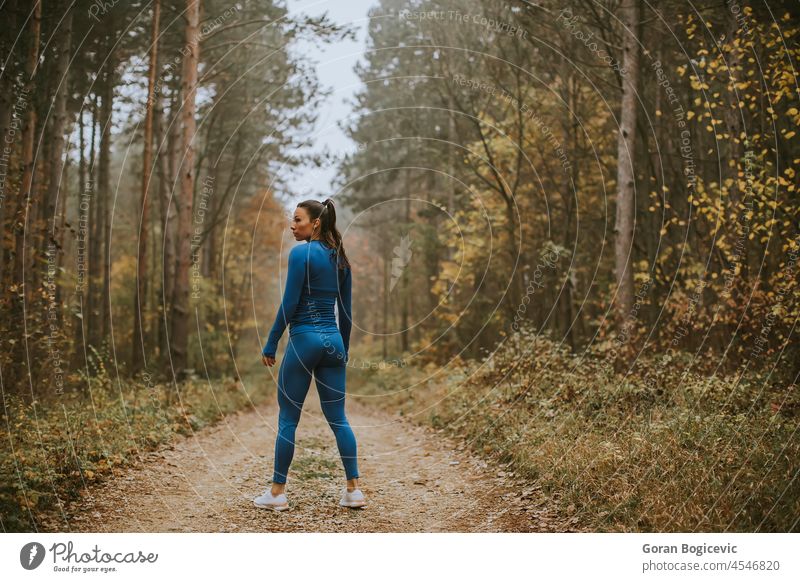 Junge Frau macht eine Pause beim Sport im Freien auf einem Waldweg im Herbst ruhen aussruhen Aktivität Erwachsener Athlet sportlich attraktiv blau Kaukasier