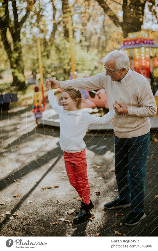 Großvater hat Spaß mit seiner kleinen Enkelin im Vergnügungspark Kind Feiertag Mann Mädchen Senior Liebe Kaukasier älter Wochenende Fröhlichkeit Saison Freizeit