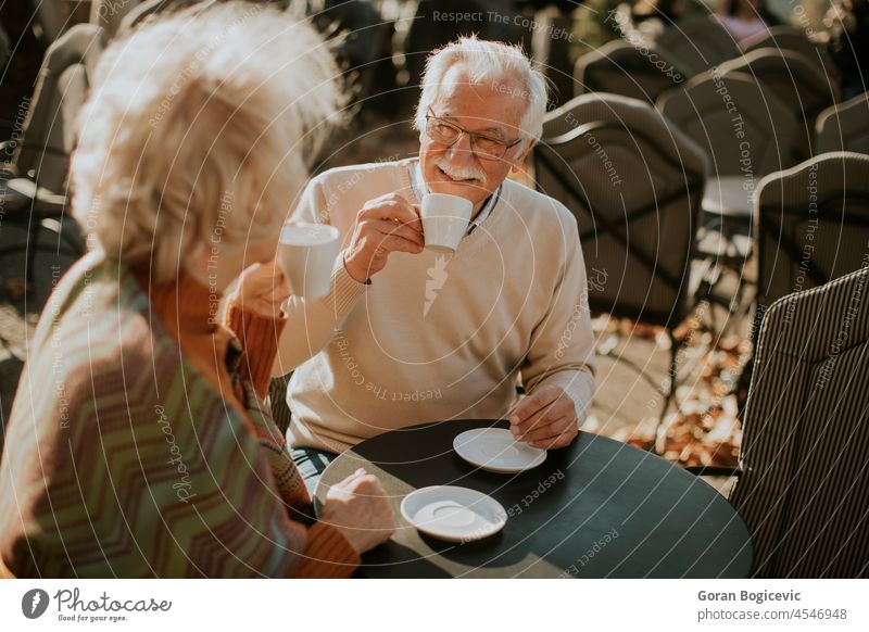 Älteres Paar trinkt Kaffee im Café im Freien an einem sonnigen Herbsttag Kaukasier sprechend Mann Tisch alt Menschen Senior Frau reif Glück Zusammensein trinken