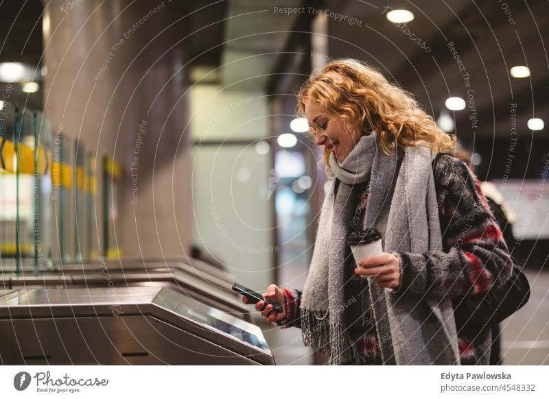 Junge Frau beim Auschecken in einer U-Bahn-Station mit Mobiltelefon eine Person Erwachsener schön lässig Mädchen Menschen Lifestyle urban Großstadt Straße