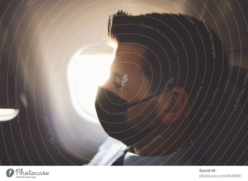 mit Maske / Atemschutzmaske im Flugzeug Corona reisen Urlaub Pandemie Schützen Schutz Prävention Mundschutz fliegen Passagier Coronavirus Delta-Variante