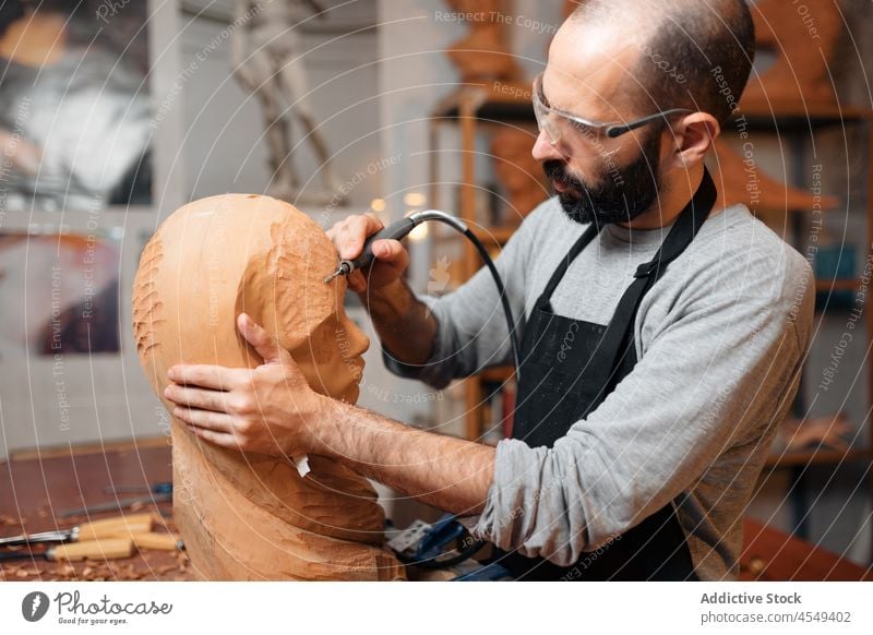 Handwerker schnitzt Holzskulptur in der Werkstatt Zimmerer Graveur schnitzen Bildhauerei Tischlerarbeit Holzarbeiten Instrument Herstellung professionell