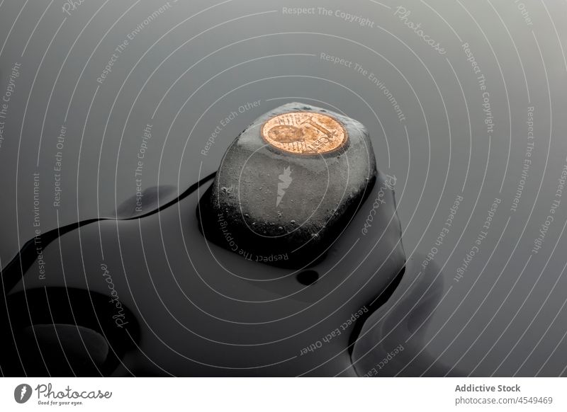 Schmelzender Eiswürfel mit Münze gefroren zerlaufen Geldmünzen kalt konservieren frieren sparen Wasser durchsichtig nass Form Frost Oberfläche übersichtlich