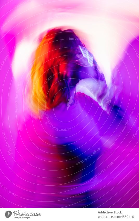 Junge Frau mit Led-Brille Augen im Studio Videospiel kreativ futuristisch Virtuelle Realität Metaversum neonfarbig Langzeitbelichtung Licht farbenfroh leuchten