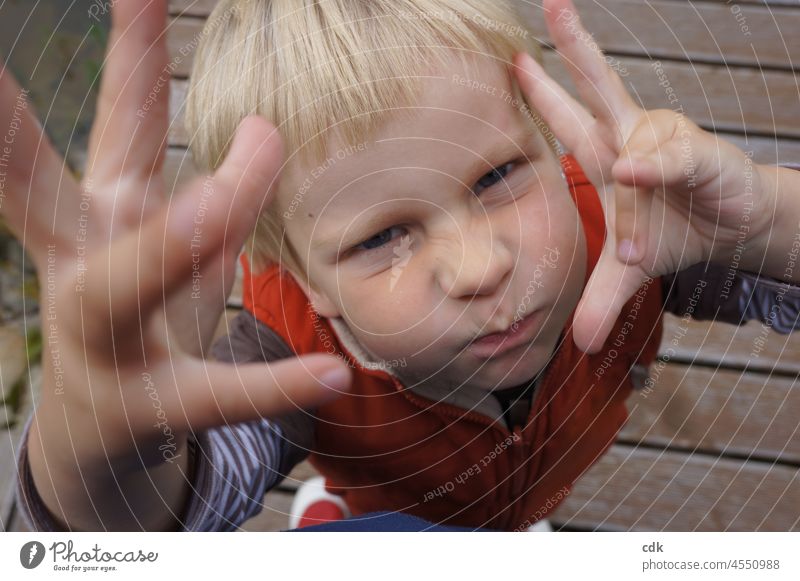 Kindheit | Genug jetzt!! Junge Grimasse Hände Gesten Gestik Gesicht Blickkontakt blond draußen stehend gestikulierend orange Weste Zeichensprache Rümpfnäschen