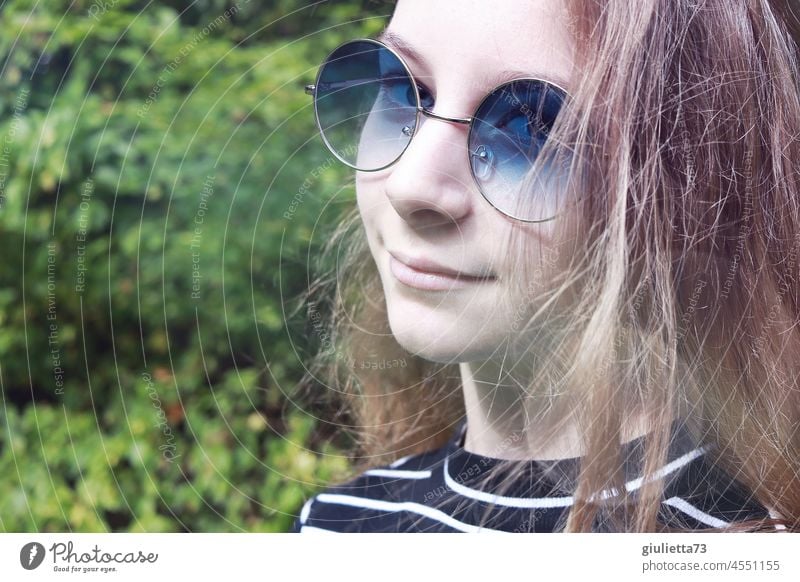 My world is sky blue | Porträt eines 12jährigen Mädchens mit langen Haaren und blauer Sonnenbrille Blick in die Kamera Halbprofil Vorderansicht