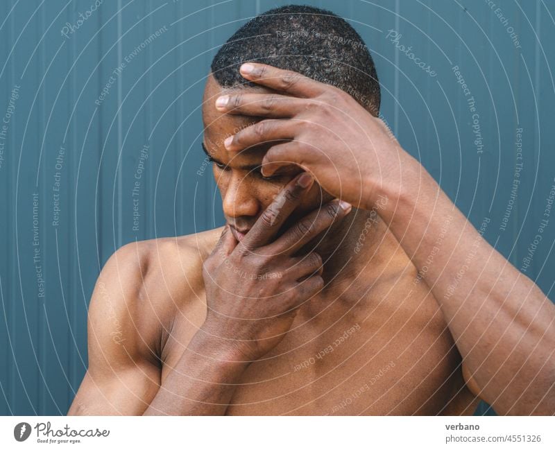 Porträt eines jungen oben ohne athetischen afrikanischen Mannes auf grauem Hintergrund im Freien Afro-Look Afrikanisch Amerikaner männlich Ausdruck ohne Hemd
