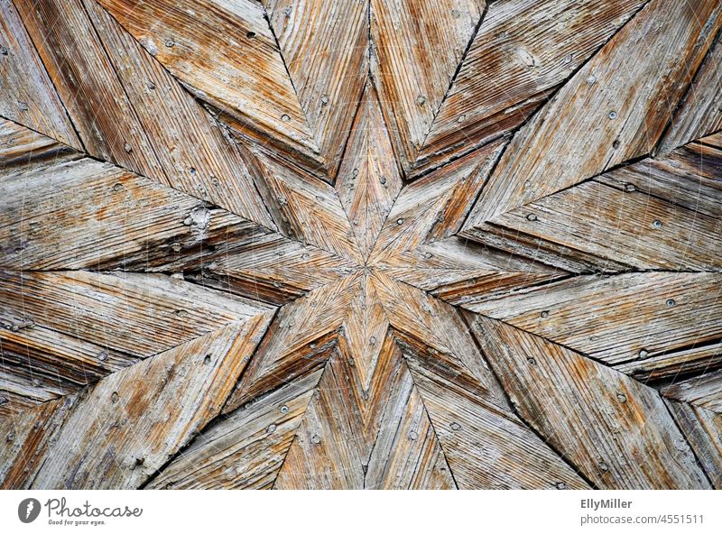 Sternenförmige Verzierung an einer alten verwitterten Holztür. Hintergrund sternenförmig Kunst Handwerk Detailaufnahme Nahaufnahme braun Strukturen & Formen