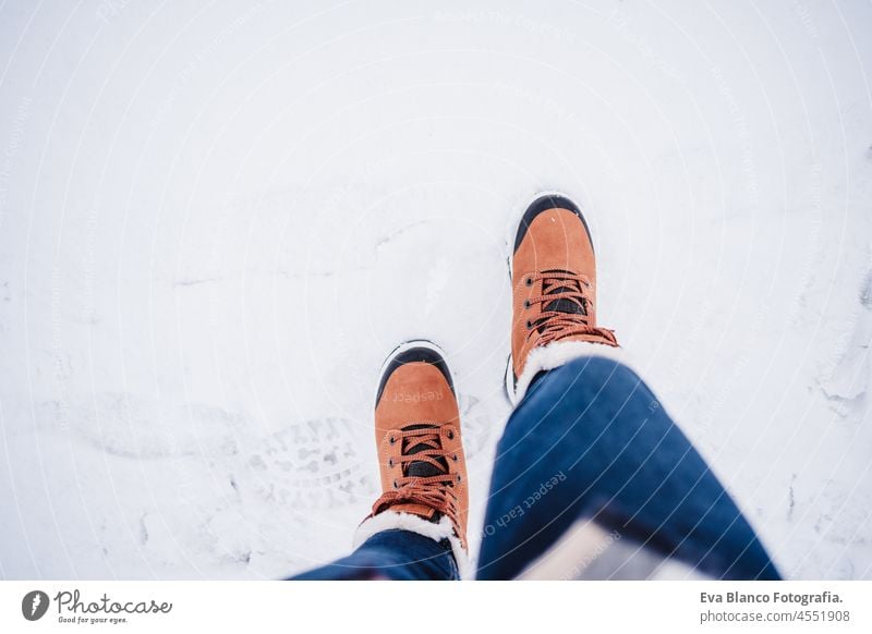 unerkennbar weiblichen Füße Stiefel zu Fuß auf verschneite Landschaft im Winter. Wandern Konzept, Draufsicht Beine Frau Schnee laufen wandern allein modern