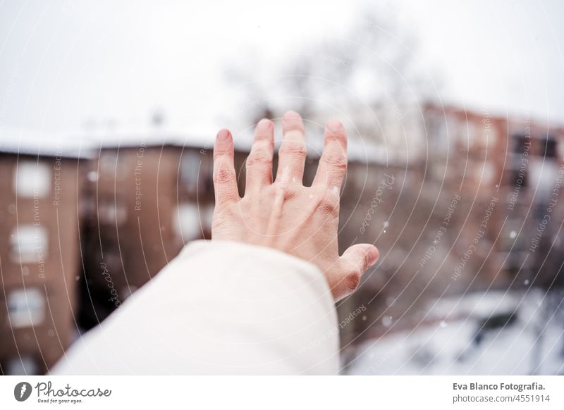 unerkennbar Frau Hand berühren Schneeflocken im Winter in der Stadt, Nachbarschaft Hintergrund. Winter-Lifestyle in der Stadt Schneefall unkenntlich Kaukasier