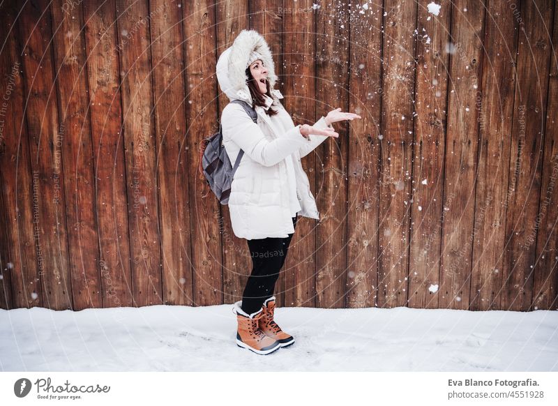 Fröhliche kaukasische junge Frau, die im Freien mit Schnee und Schneeflocken spielt, Spaß und Winterleben Spielen Park Kaukasier Berge u. Gebirge Schneefall