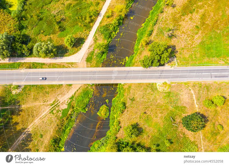 Luftaufnahmen mit einer Drohne. Fliegen über einen schönen grünen Wald in einer ländlichen Landschaft. Draufsicht auf Bäume im Waldhintergrund. Drohnen-Fotografie. Wald Fluss, ländliche Straße.
