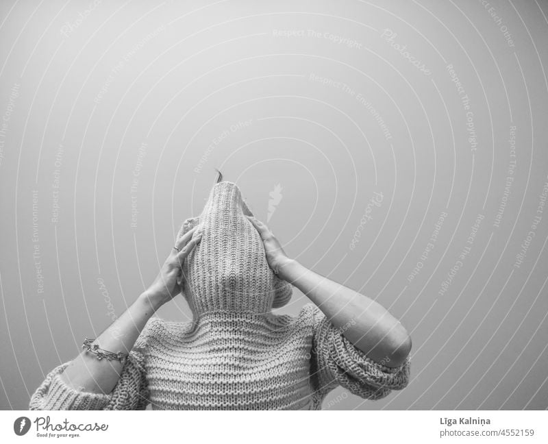 Anonyme Frau in übergroßem Pullover hält ihren Kopf Wollpullover Strickpullover Wärme Mensch Innenaufnahme weich Winter gestrickt Mode gemütlich Oberkörper