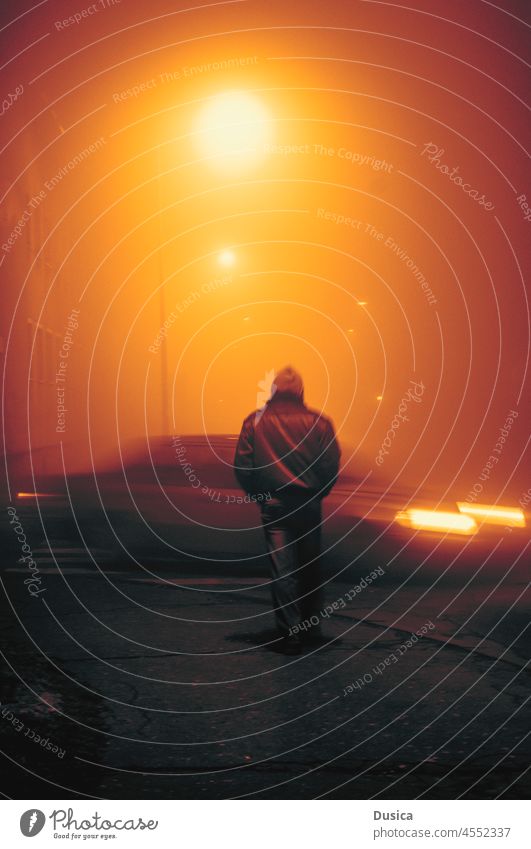Mann auf einer Straße bei Nebel und ein vorbeifahrendes Auto neblig geheimnisvoll Thriller Buchumschlag atmosphärisch Wetter Nacht Abend Lichter urban laufen