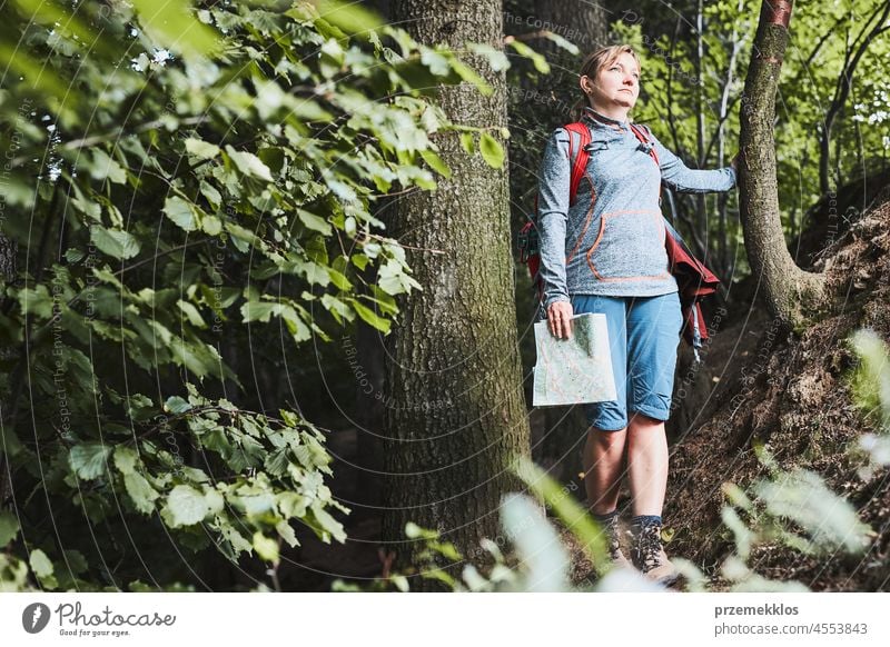 Aktive Frau, die auf einem Waldweg spazieren geht und ihren Sommerurlaub aktiv verbringt Ausflug reisen Reise Abenteuer Aktivität Rucksack Spaß Trekking Urlaub