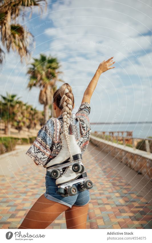 Unbekannte Frau mit Rollschuhen läuft auf einer Böschung Rollerskate Straße sportlich Hobby Bürgersteig Training Aktivität Gesunder Lebensstil Stauanlage