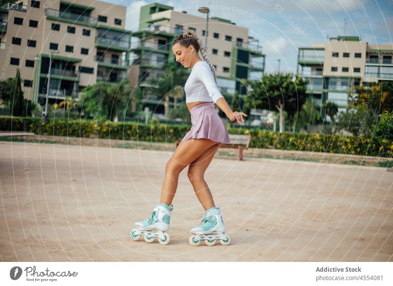 Frau beim Schlittschuhlaufen auf dem Platz einer Wohnsiedlung. Rollerskate Straße sportlich Hobby Bürgersteig Aktivität Training Wohlbefinden