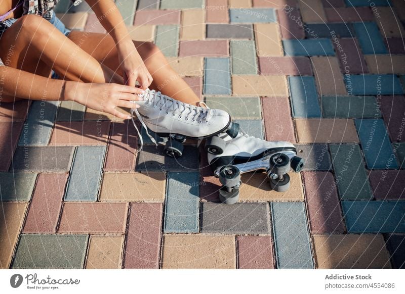 Anonyme Frau beim Binden von Rollschuhen auf der Straße Rollerskate sportlich Hobby Bürgersteig Aktivität Training Wohlbefinden Gesunder Lebensstil Sport Schuhe