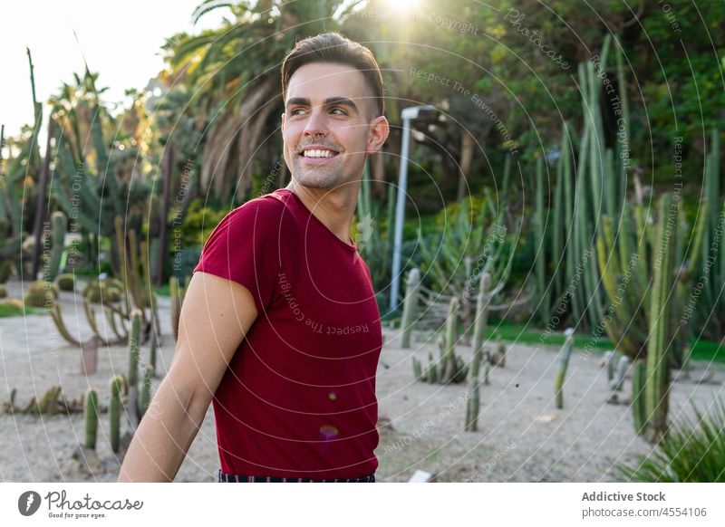 Positiv eingestellter Mann, der in einem tropischen Garten wegschaut Resort Sommer Feiertag Urlaub exotisch selbstbewusst Natur männlich jung ethnisch