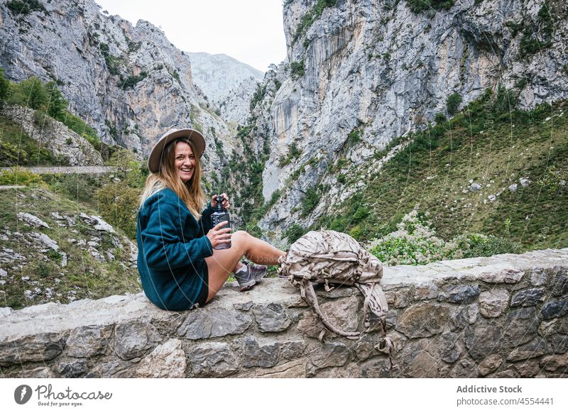 Frau trinkt Wasser aus einer Flasche an einer steinigen Grenze in den Bergen trinken Durst Hochland Landschaft Berge u. Gebirge Wanderung Berghang Freiheit