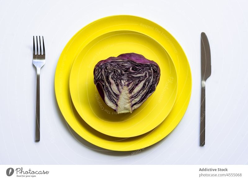 Gelbe Teller mit geschnittenem Rotkohl Kohlgewächse roh frisch Gesundheit Gemüse halbiert Lebensmittel Vitamin reif Hälfte Gabel Messer Streifen sehr wenige