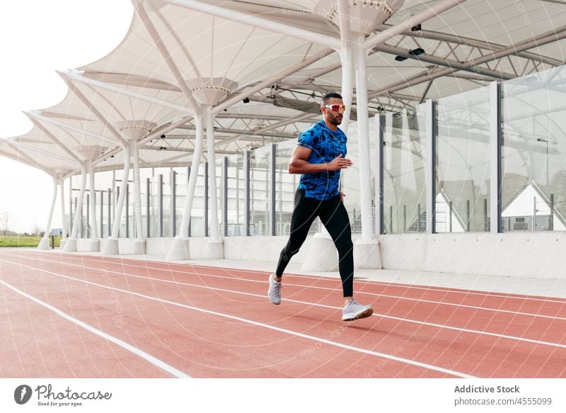 Sportlicher Mann beim Laufen auf der Laufbahn gutaussehend männlich ethnisch Afrikanisch junger Erwachsener Athlet Sportbekleidung rennen Läufer Training