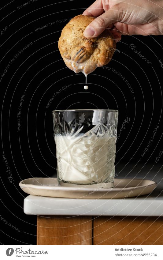 Unbekannte Person taucht Keks in Milch melken Dip süß Dessert Gebäck gebacken selbstgemacht Konfekt kulinarisch Lebensmittel geschmackvoll Tisch Leckerbissen