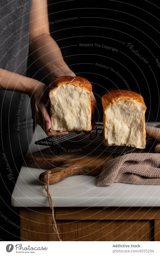Crop Cook mit Sandwichbrot in dunkler Küche Koch Bäcker Brot Hälfte Split Belegtes Brot geschmackvoll gebacken lecker Lebensmittel Brotlaib appetitlich