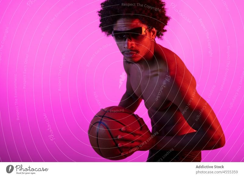 Schwarzer Mann ohne Hemd mit Basketball Sportler nackter Torso neonfarbig fluoreszierend muskulös Vorschein Individualität männlich Afroamerikaner schwarz
