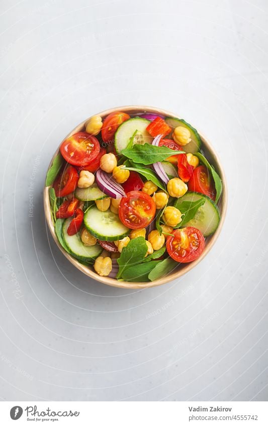 Vegetarischer Kichererbsen-Bohnen-Salat, zubereitet mit Tomaten und Gurken in einer Papierschüssel. Abfallfreies Geschirr, Ansicht von oben Salatbeilage