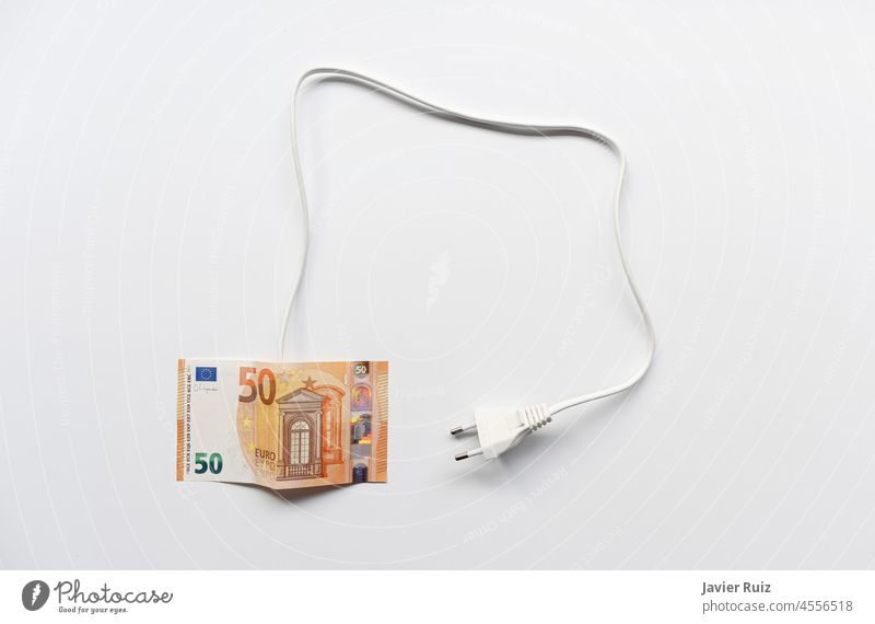 eine Fünfzig-Euro-Rechnung mit einem Kabel und einem Stecker auf weißem Hintergrund, Energiepreisproblem, Stromtarife Preis Stromrechnung teuer fünfzig Geld