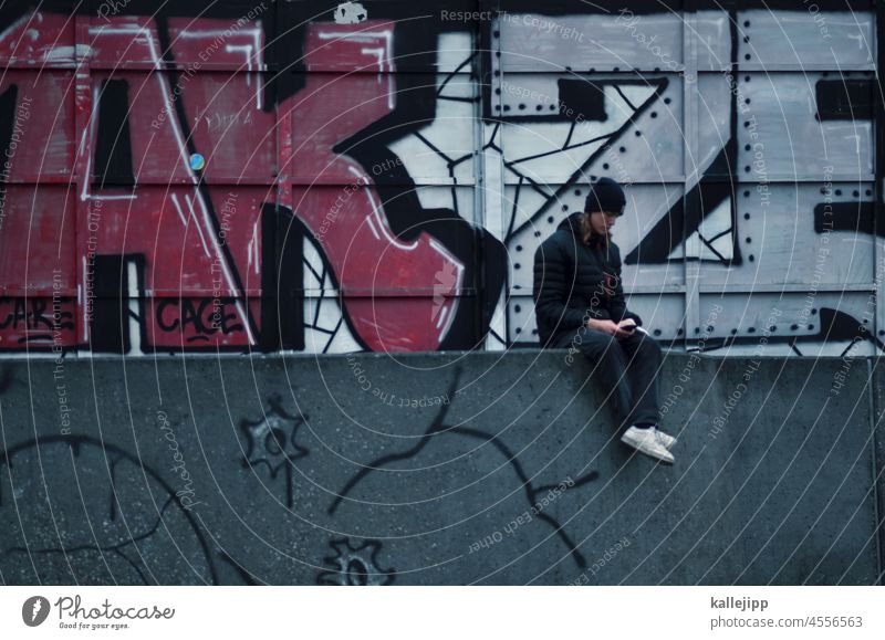 speicherplatz jugendlicher Jugendlicher Teenager jung im Freien Lifestyle Schüler urban Graffiti Handy Mobile Straße lässig Medien Mütze Mauer sitzen streetart