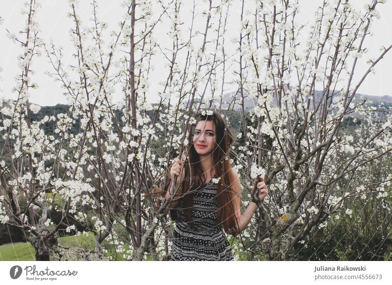 junge Frau zwischen Kirschblüten langes Haar Lifestyle elegant trendy Freude fröhlich lachen Fröhlichkeit Stil Gefühle Modefotografie Modell draußen hübsch