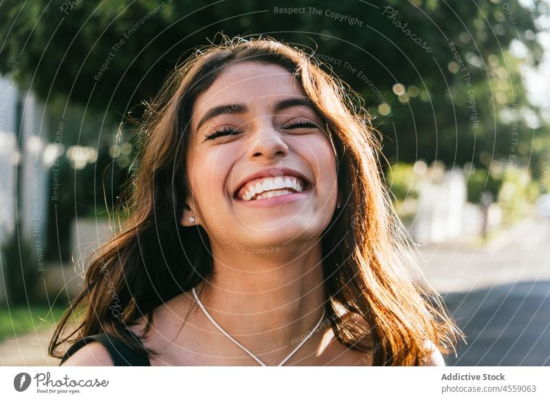 Glückliche Frau genießt Sommertag auf der Straße Porträt Inhalt Augen geschlossen Lächeln heiter expressiv Freude positiv angenehm hispanisch ethnisch