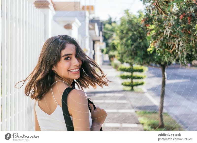 Glückliche Frau genießt Sommertag auf der Straße Porträt Inhalt Lächeln heiter expressiv Freude positiv angenehm hispanisch ethnisch sorgenfrei dunkles Haar