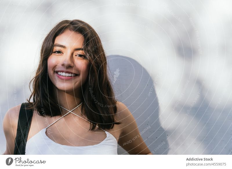 Positive Brünette auf weißem Hintergrund Frau Porträt Inhalt Lächeln heiter expressiv Freude positiv Glück angenehm hispanisch ethnisch sorgenfrei dunkles Haar