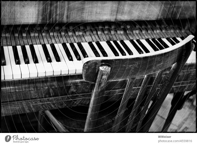Wahrscheinlich hat schon lange niemand mehr auf diesem Stuhl gesessen und auf dem alten Klavier gespielt Tasten Musik spielen musizieren verstimmt verlassen